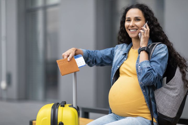 cheerful-expecting-lady-waiting-taxi-airport-using-phone-2-scaled.jpg