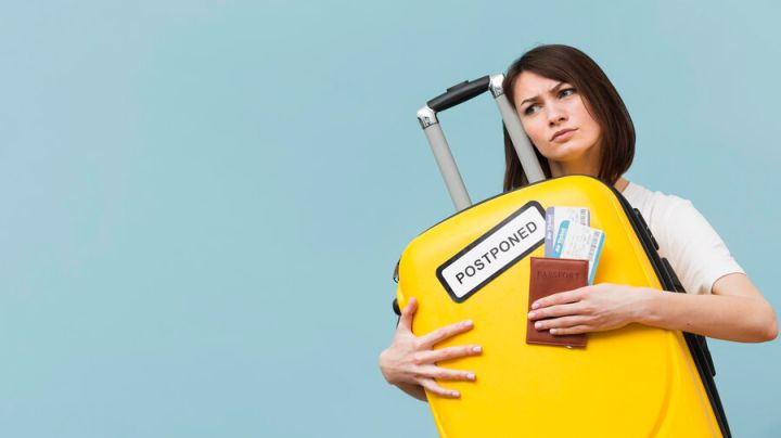 woman-holding-yellow-baggage-with-postponed-sign-with-copy-space_23-2148596908.jpg