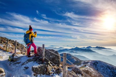 young-woman-hiker-taking-photo-with-smartphone-mountains-peak-winter-1-1.jpg